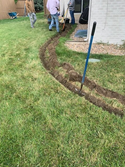 Digging french drain trench with shovels